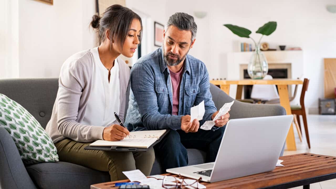 Tax Incentives For Energy Efficiency & Fortified Roof Picture of a couple sitting on the sofa in their living room discussing finances.
